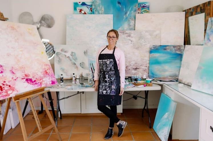 Ritushka’s studio with large abstract landscape and seascape canvases stacked wall to wall